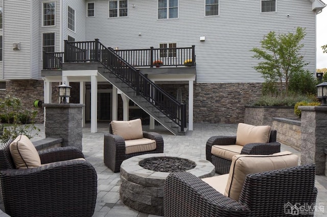 view of patio with an outdoor living space with a fire pit