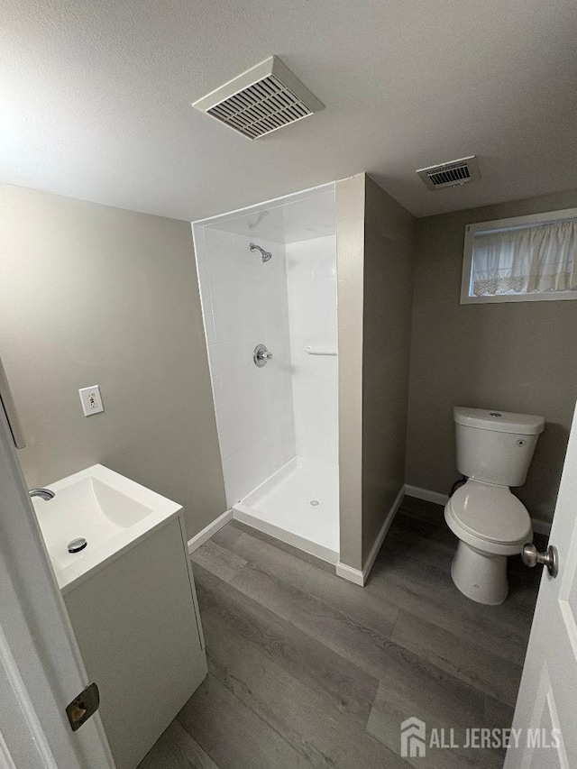 full bath featuring walk in shower, toilet, visible vents, and wood finished floors