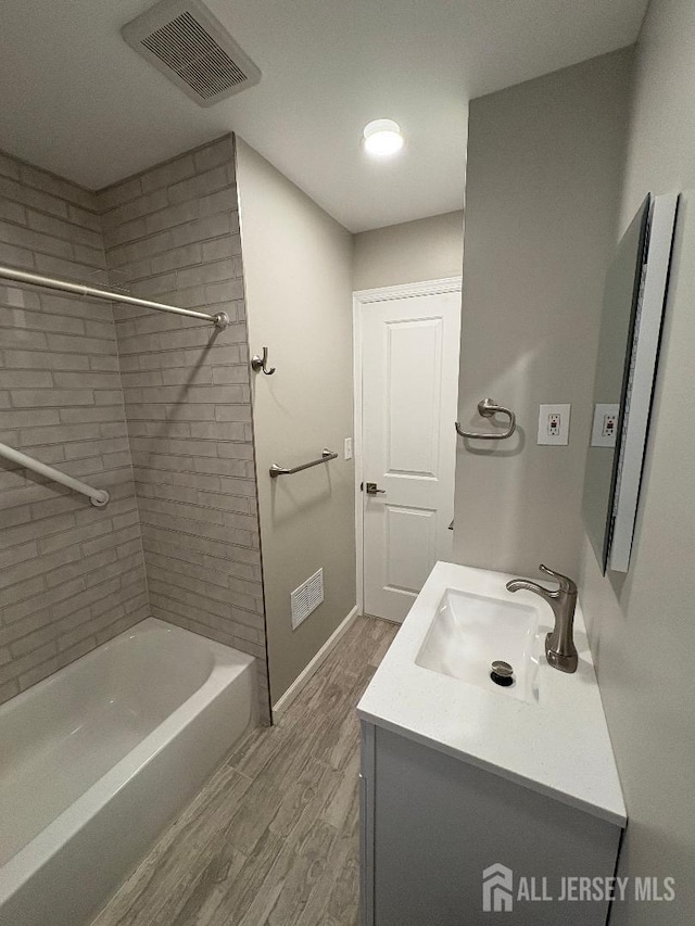 bathroom with baseboards, visible vents, wood finished floors, and vanity