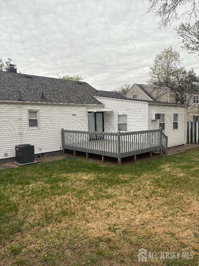 28 Maplewood Ave, Colonia, NJ 07067 - rear view of house featuring a deck, cooling unit, a lawn, and roof with shingles