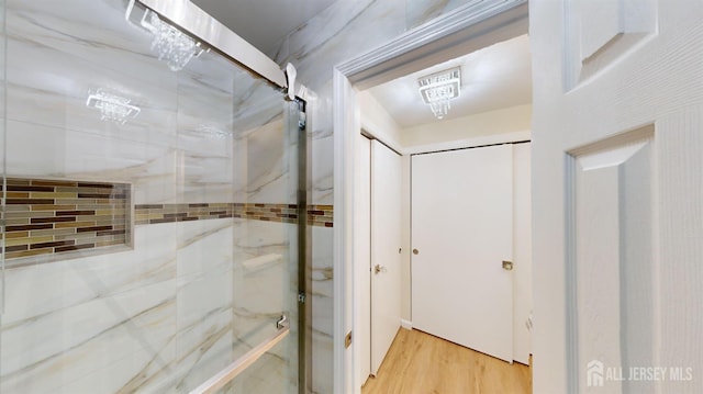 bathroom with walk in shower and wood finished floors