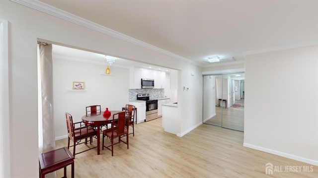 dining room featuring light wood-type flooring, ornamental molding, baseboards, and a fireplace