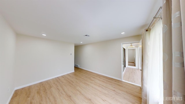 empty room with baseboards, recessed lighting, and light wood-style flooring