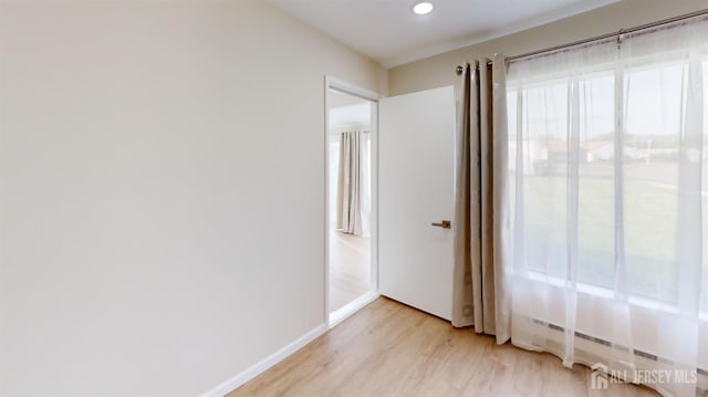 spare room featuring baseboards, recessed lighting, and light wood-style flooring