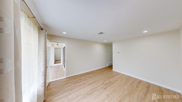 spare room with recessed lighting, baseboards, light wood-type flooring, a baseboard radiator, and visible vents