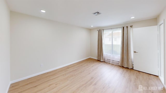 spare room featuring recessed lighting, baseboards, light wood-type flooring, and visible vents