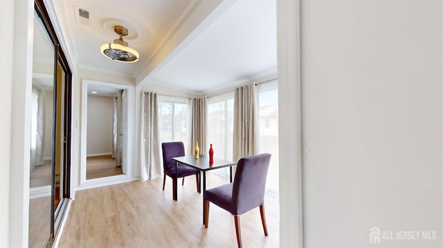 dining room with crown molding, visible vents, beam ceiling, baseboards, and light wood finished floors