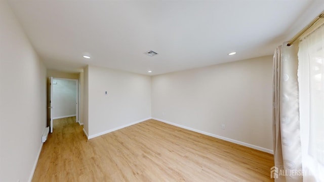 spare room featuring recessed lighting, baseboards, light wood-type flooring, and visible vents