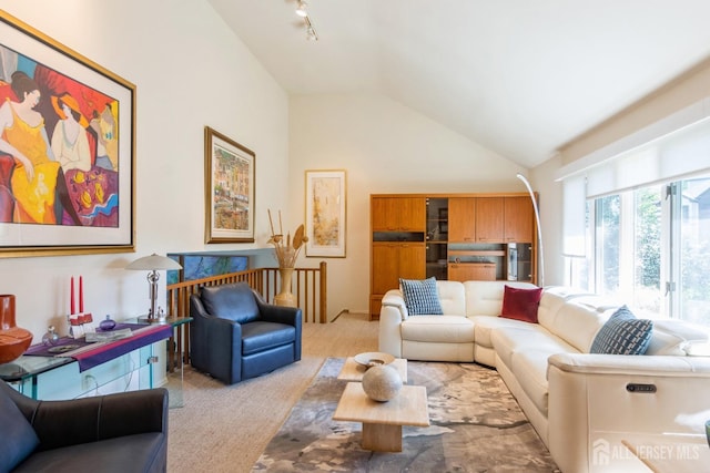 living room featuring light carpet, track lighting, and high vaulted ceiling