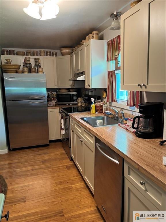107 Readington Rd, Readington, NJ 08889 - kitchen featuring appliances with stainless steel finishes, extractor fan, butcher block counters, and light wood-type flooring