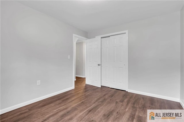 1092 Woodruff St, Iselin, NJ 08830 - unfurnished bedroom featuring wood finished floors, baseboards, and a closet