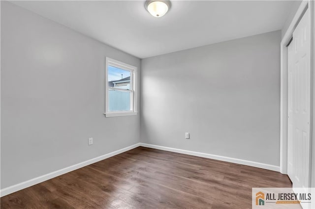 1092 Woodruff St, Iselin, NJ 08830 - unfurnished bedroom featuring a closet, baseboards, and dark wood-style floors