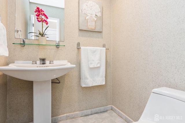 bathroom with tile patterned floors, toilet, and baseboards