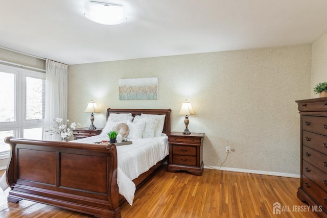 bedroom with wood finished floors and baseboards