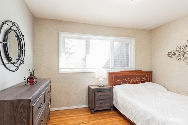 bedroom with light wood-type flooring and baseboards