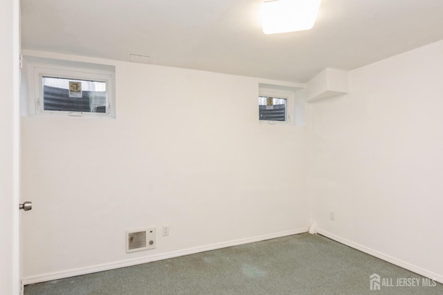 basement with baseboards and visible vents