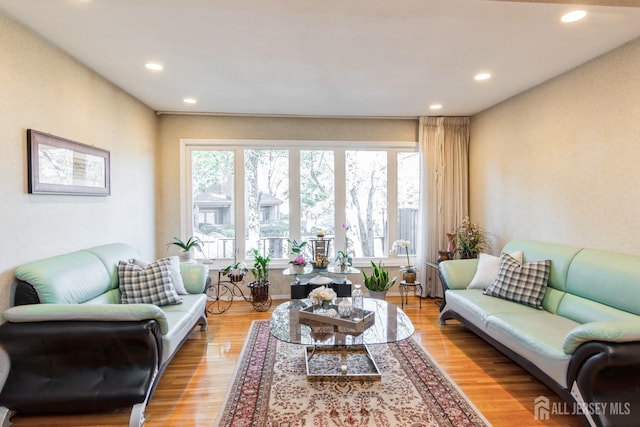 living area with a wealth of natural light, light wood-type flooring, and recessed lighting