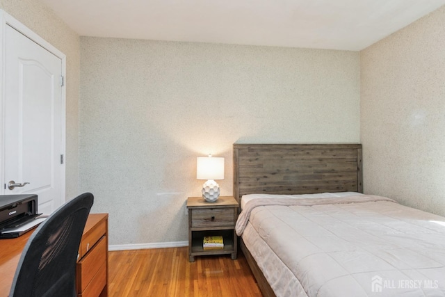 bedroom featuring wood finished floors and baseboards