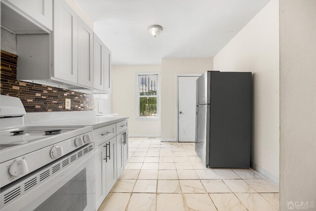 kitchen with white electric range oven, stainless steel fridge, decorative backsplash, and white cabinetry