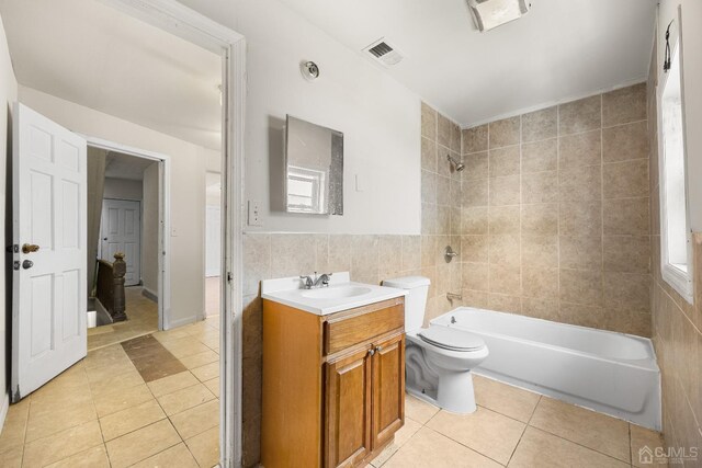 full bathroom featuring tile patterned flooring, vanity, toilet, and tile walls