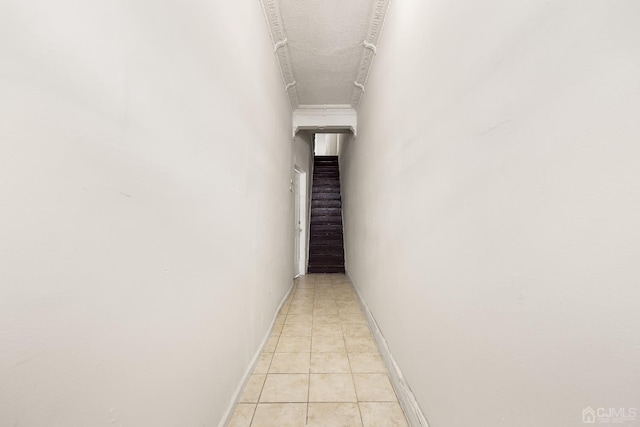 hall featuring light tile patterned floors and a textured ceiling