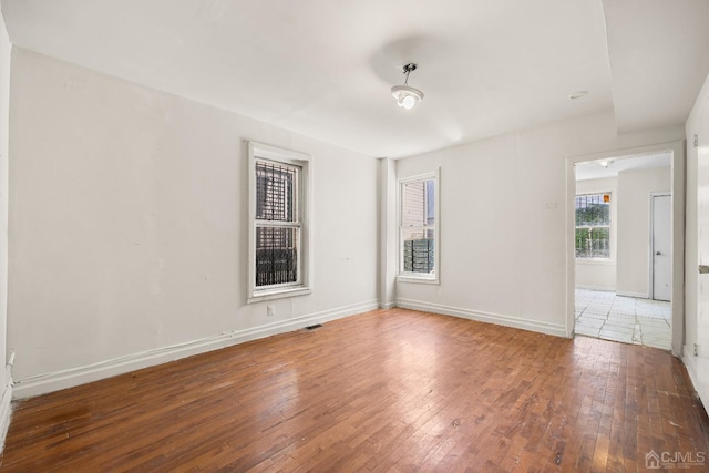 unfurnished room with dark wood-type flooring