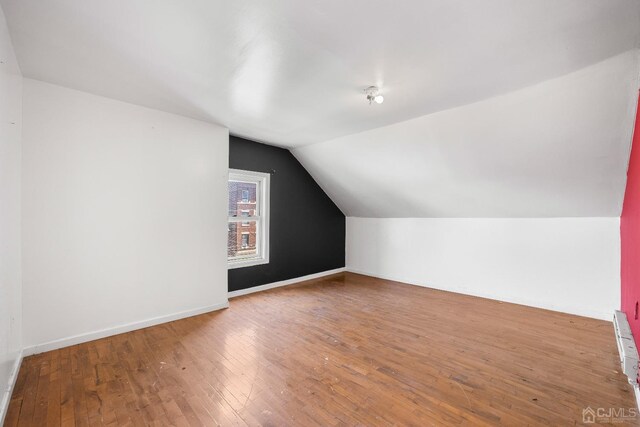 additional living space featuring hardwood / wood-style flooring and lofted ceiling