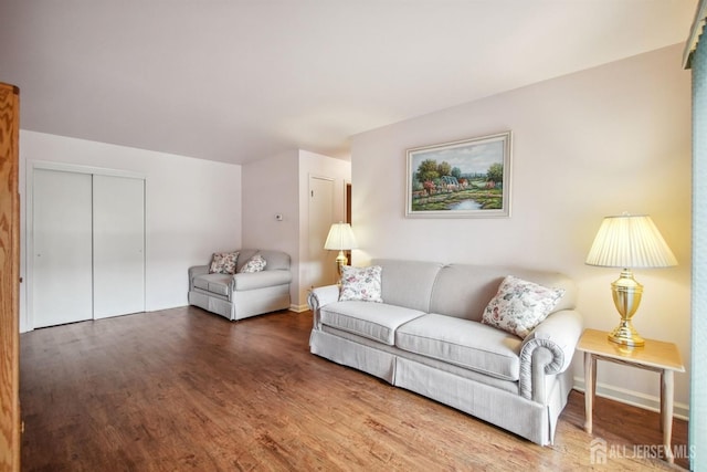 living area with baseboards and wood finished floors