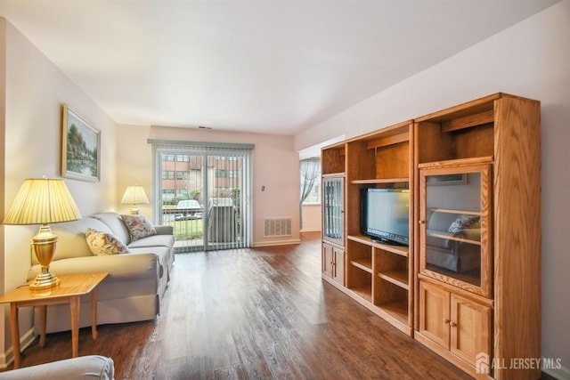 living area featuring dark wood-style floors, visible vents, and baseboards