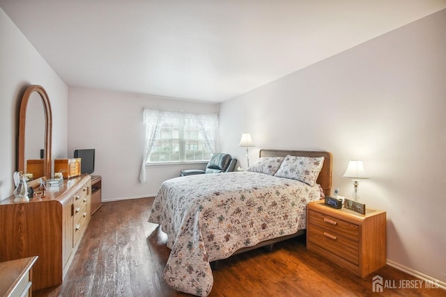 bedroom with dark wood finished floors and baseboards