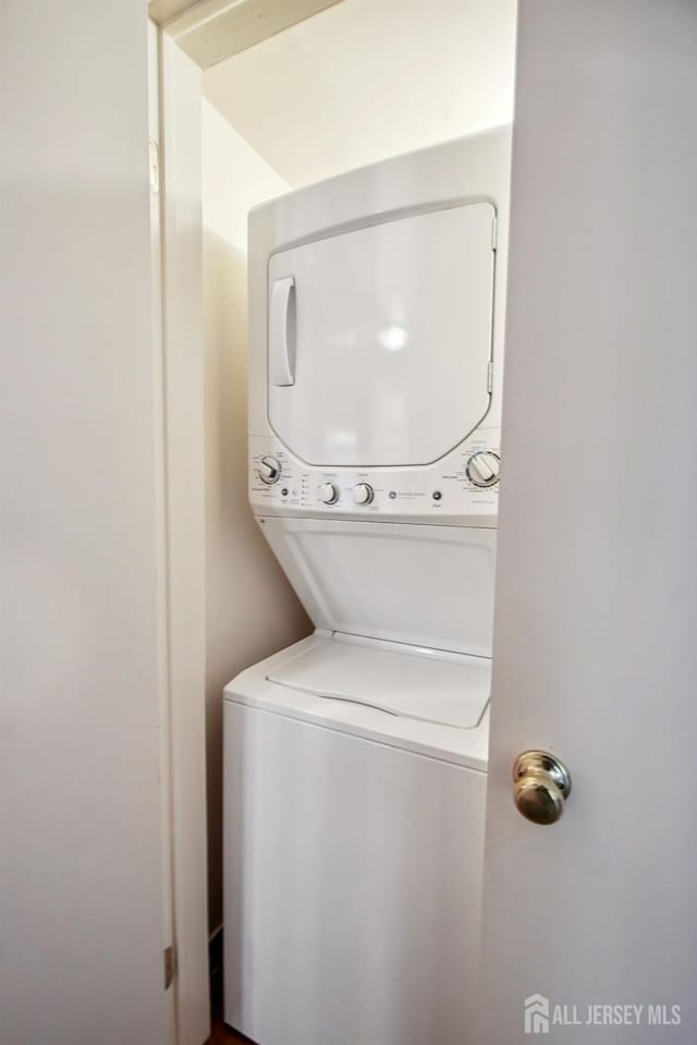 clothes washing area featuring laundry area and stacked washer / dryer