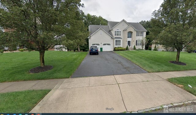 view of front of house with a front yard and a garage