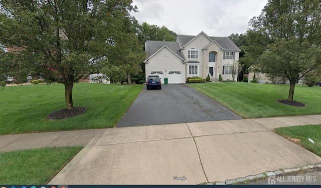 view of front of home featuring a garage, driveway, and a front yard