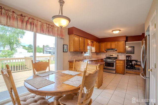 5 Wetherhill Way S, Brunswick, NJ 08810 - kitchen with stainless steel appliances, decorative backsplash, light tile patterned flooring, brown cabinets, and under cabinet range hood