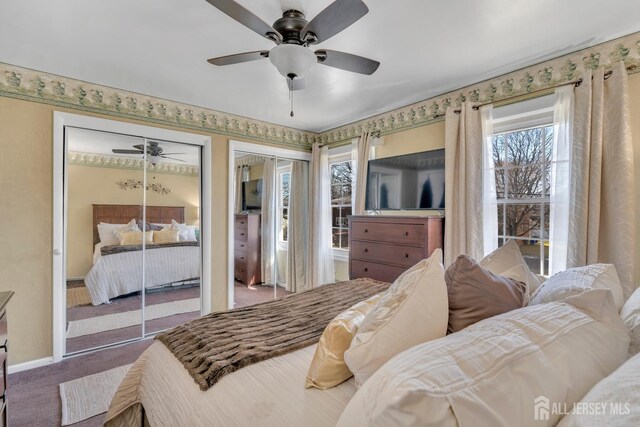 bedroom with carpet flooring, baseboards, ceiling fan, and multiple closets