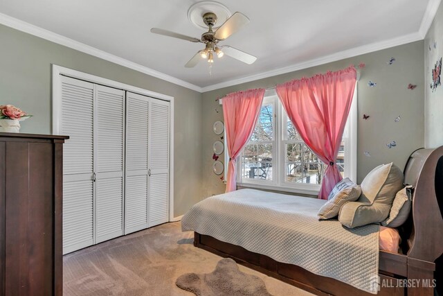 bedroom with crown molding, a closet, carpet flooring, and ceiling fan