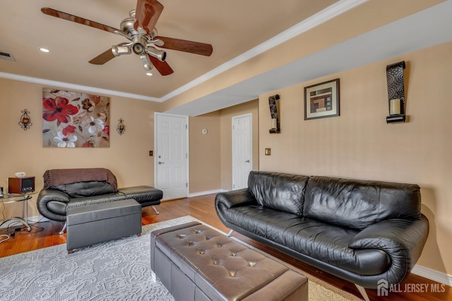 living area with wood finished floors, ceiling fan, crown molding, and baseboards
