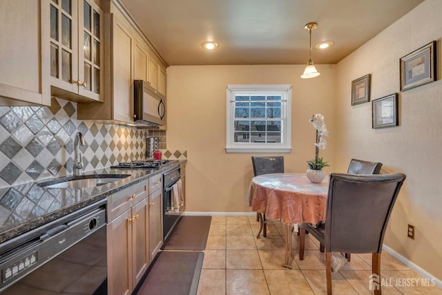 kitchen featuring dark stone counters, a sink, glass insert cabinets, black appliances, and backsplash