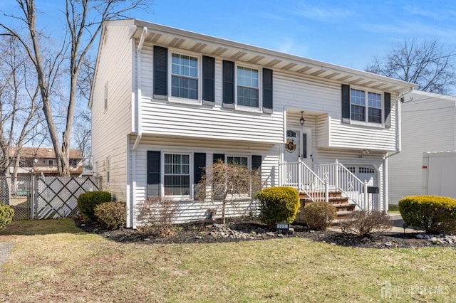 split foyer home with fence and a front lawn