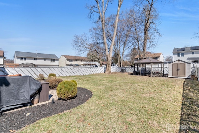 view of yard with fence, a storage shed, a gazebo, and an outdoor structure