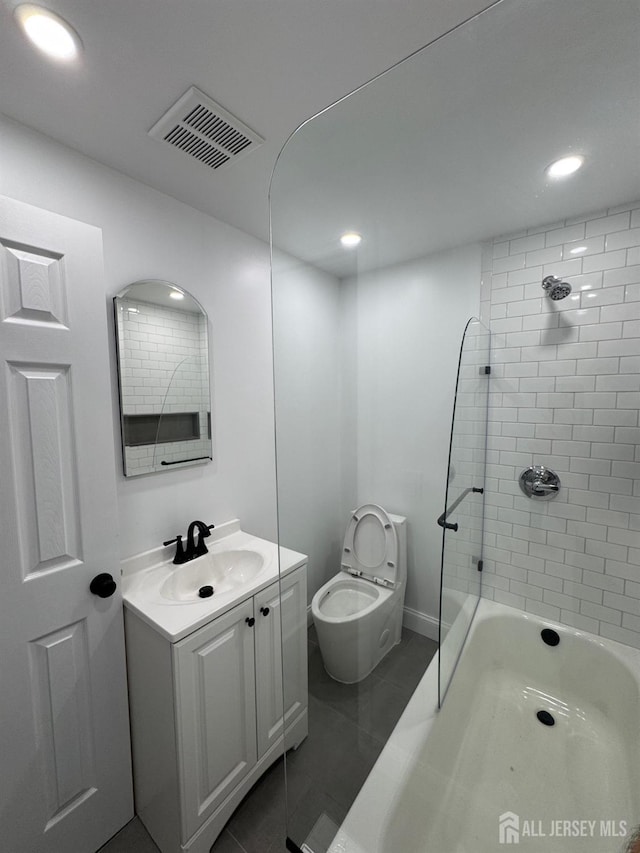 full bathroom with vanity, tiled shower / bath, tile patterned flooring, and toilet