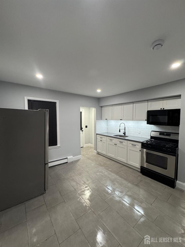 kitchen featuring appliances with stainless steel finishes, tasteful backsplash, sink, white cabinets, and baseboard heating