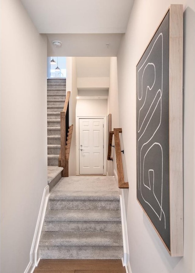 stairway with baseboards and wood finished floors