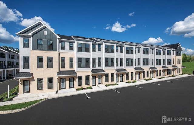 view of building exterior featuring a residential view and uncovered parking