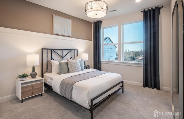 bedroom featuring visible vents, baseboards, and light colored carpet