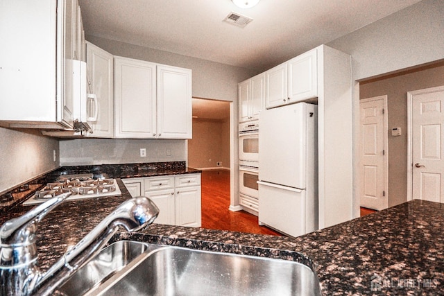 kitchen featuring visible vents, white appliances, dark wood-type flooring, and white cabinetry