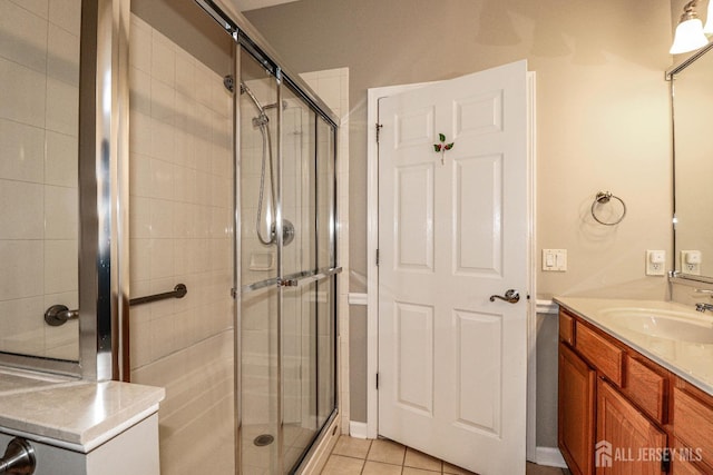 full bath with vanity, a shower stall, and tile patterned flooring