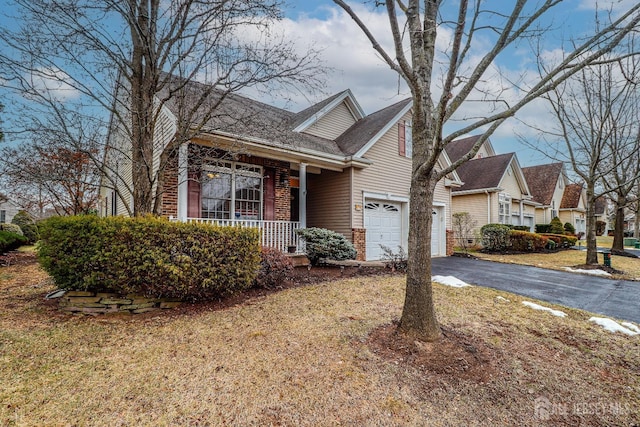 view of front of home featuring aphalt driveway, a porch, and brick siding