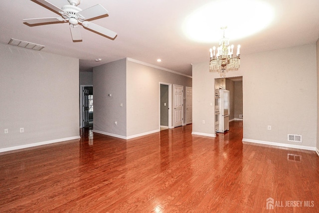 spare room with visible vents, baseboards, wood finished floors, and ceiling fan with notable chandelier