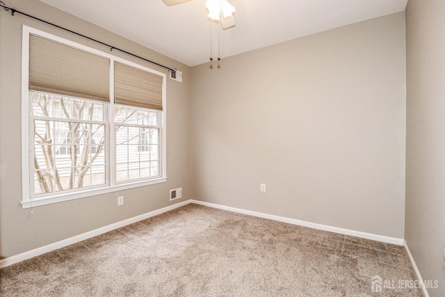 spare room with visible vents, carpet flooring, a ceiling fan, and baseboards